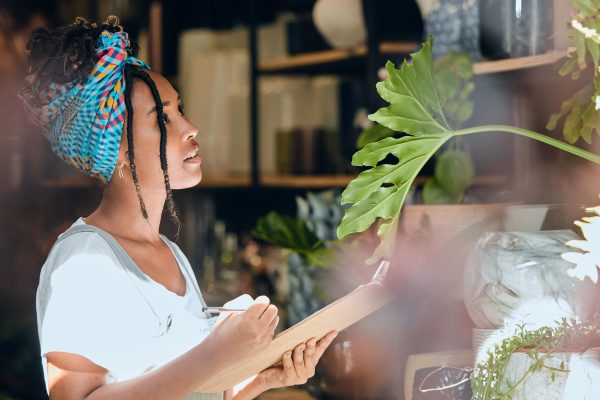 Small business owner taking inventory in her Denver plant shop.