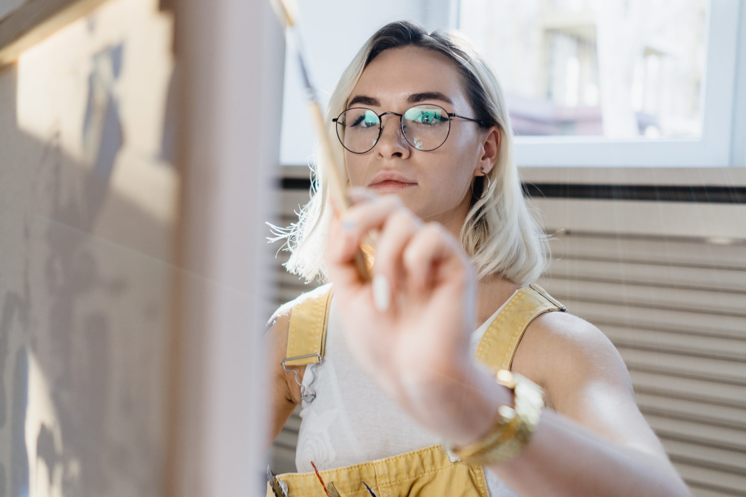 Female artist drawing in a comfy art studio in Denver, creating custom art for sale.
